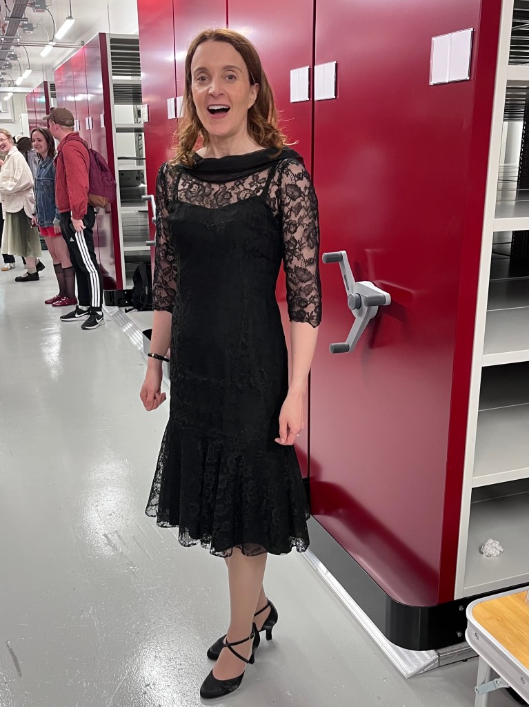 Actress Maeve Fitzgerald wearing Dora's black lace cocktail dress from the 1950s.